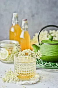 A glass of elderflower water on a decorative table